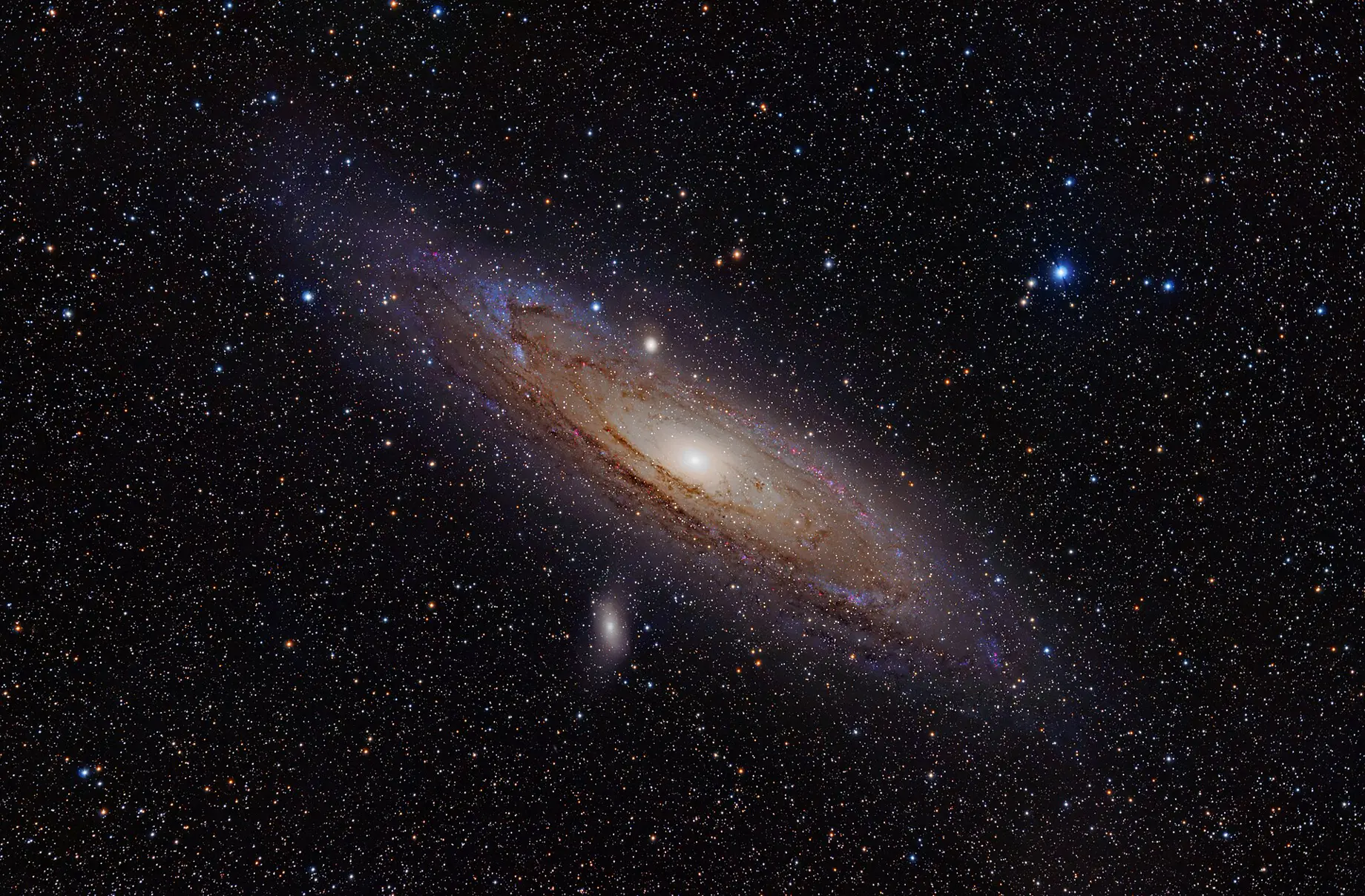 The Andromeda Galaxy, a spiral of a trillion stars with two bright satellite galaxies